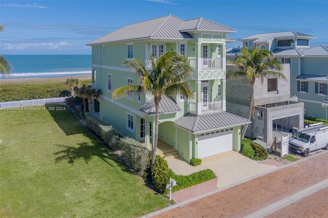 exterior space featuring a water view, a lawn, a garage, and a balcony