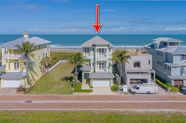 exterior space featuring a water view and a beach view