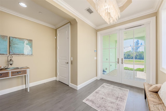 foyer entrance with hardwood / wood-style floors, ornamental molding, and french doors