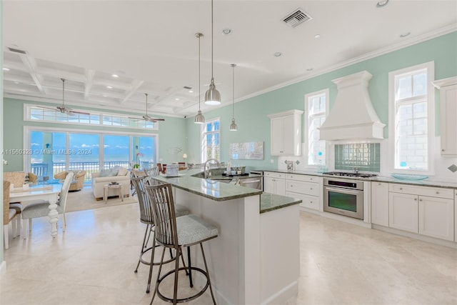 kitchen featuring premium range hood, stainless steel appliances, ceiling fan, white cabinetry, and dark stone countertops