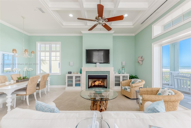 living room featuring crown molding, a healthy amount of sunlight, ceiling fan, and a fireplace