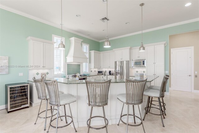 kitchen with wine cooler, a spacious island, hanging light fixtures, stainless steel appliances, and custom exhaust hood