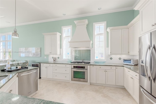 kitchen with custom range hood, stainless steel appliances, decorative backsplash, white cabinetry, and light stone counters