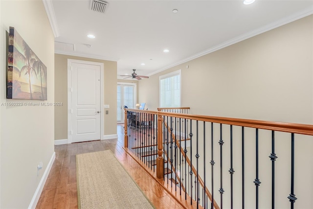 hallway featuring crown molding and light hardwood / wood-style flooring