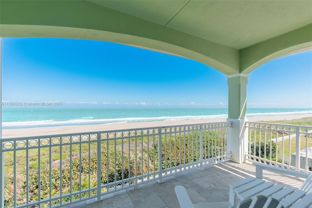 balcony featuring a beach view and a water view