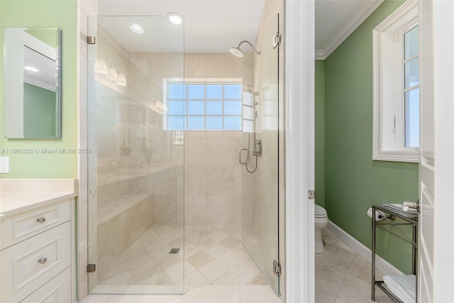 bathroom featuring ornamental molding, vanity, toilet, and a shower with shower door