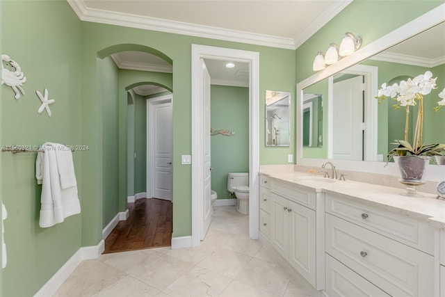 bathroom with crown molding, vanity, and toilet