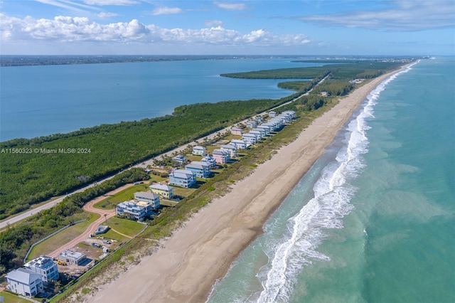 birds eye view of property featuring a beach view and a water view