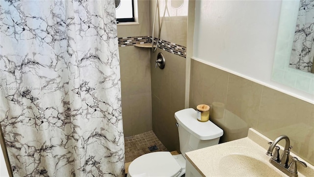 bathroom featuring toilet, tile walls, a shower with shower curtain, and vanity