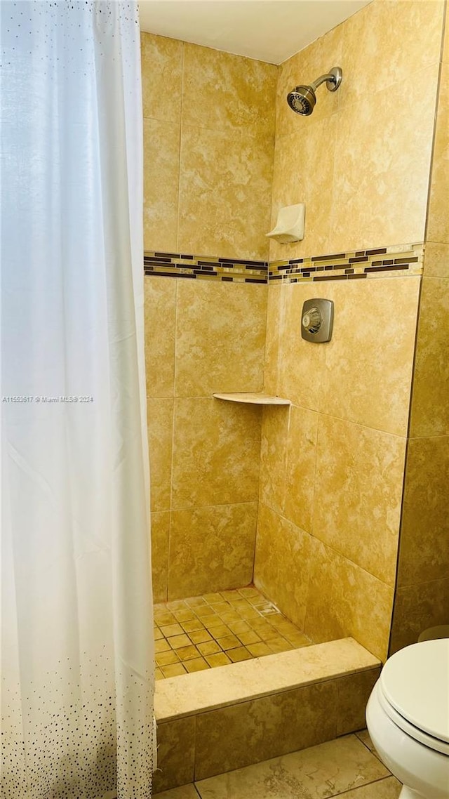 bathroom featuring tile floors, toilet, and curtained shower