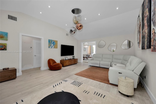 living room featuring lofted ceiling and light hardwood / wood-style flooring