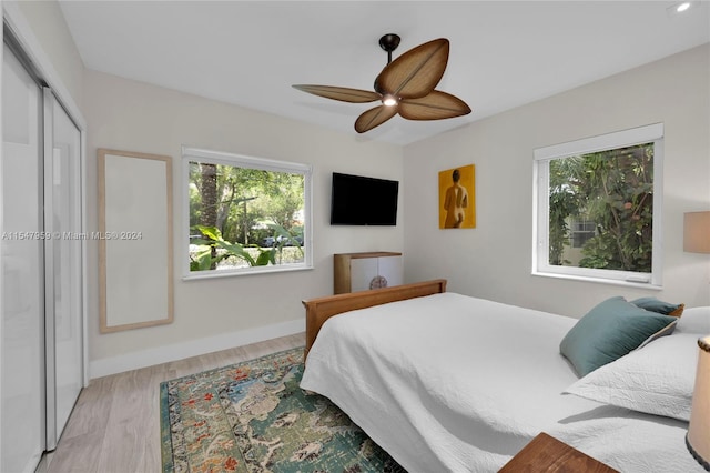 bedroom with a closet, ceiling fan, and light wood-type flooring