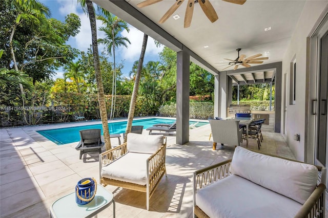 view of patio with an outdoor living space, exterior kitchen, ceiling fan, and a fenced in pool