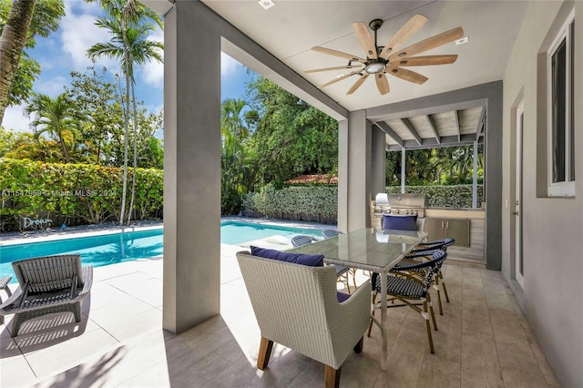 view of swimming pool with a grill, a patio area, an outdoor kitchen, and ceiling fan