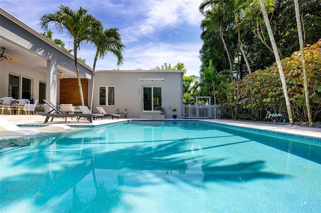 view of swimming pool with ceiling fan and a patio