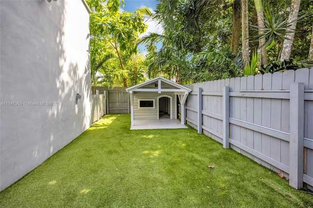 view of yard featuring an outdoor structure and a patio area