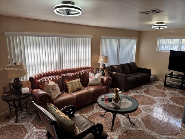 living room with light tile floors and beamed ceiling