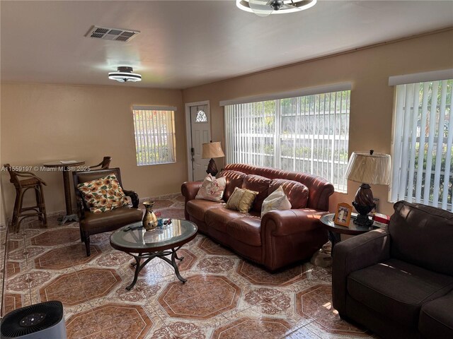 living room featuring beam ceiling and light tile floors