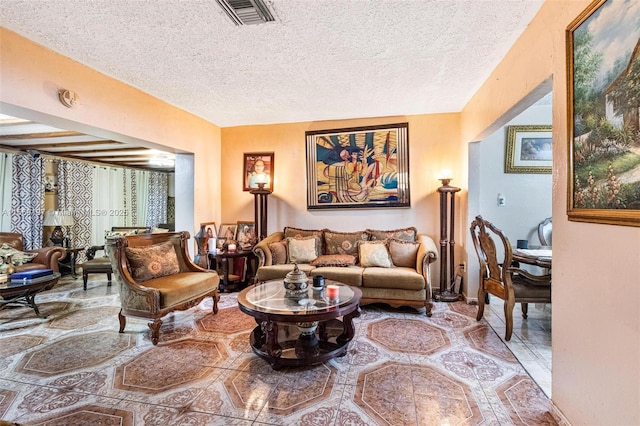 living area with visible vents and a textured ceiling