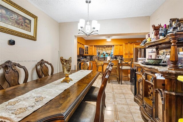 dining space with a notable chandelier, a textured ceiling, and light tile flooring