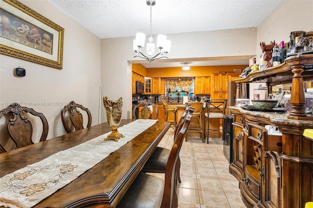 dining room featuring light tile patterned flooring, a notable chandelier, and a textured ceiling