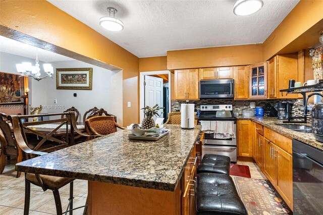 kitchen featuring a chandelier, backsplash, a breakfast bar area, stainless steel appliances, and a center island