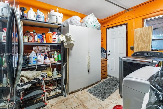 interior space with washer and clothes dryer, freestanding refrigerator, and tile patterned floors