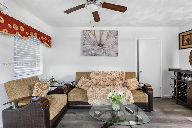 living room featuring ceiling fan and dark hardwood / wood-style flooring