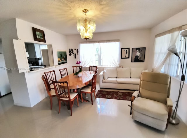 dining room with a notable chandelier, a textured ceiling, and tile floors