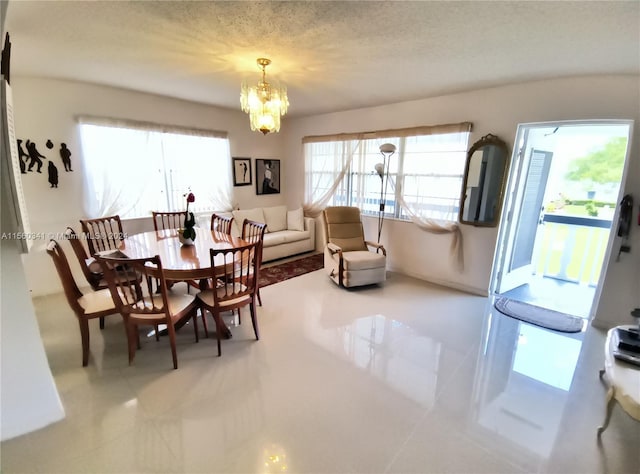 dining area featuring an inviting chandelier, a textured ceiling, a wealth of natural light, and light tile floors