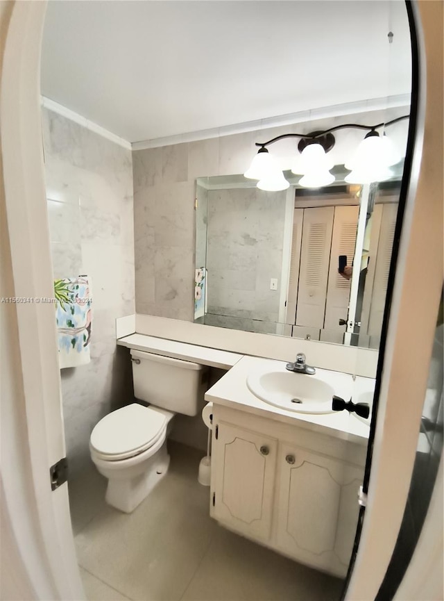 bathroom with tile flooring, toilet, large vanity, and tile walls