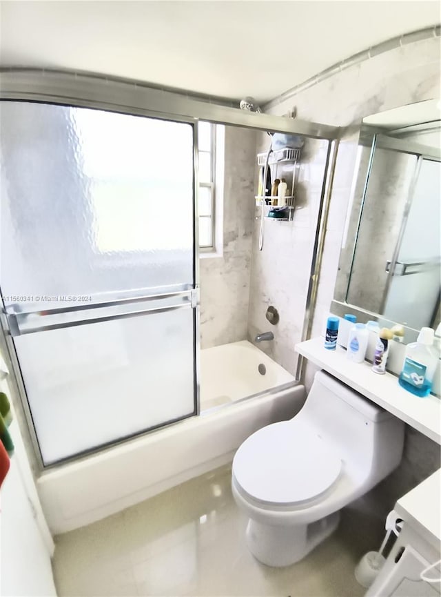 full bathroom featuring vanity, combined bath / shower with glass door, tile floors, and toilet