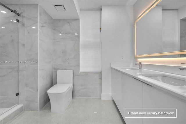 bathroom featuring tile walls, double sink vanity, toilet, tiled shower, and tile floors