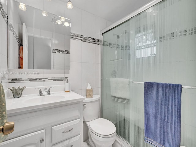 full bathroom with toilet, vanity, tile walls, backsplash, and a shower stall