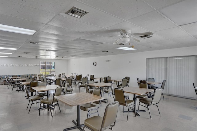 dining space with a ceiling fan, visible vents, and a drop ceiling