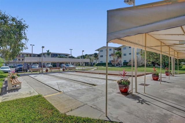 view of community with a lawn and shuffleboard