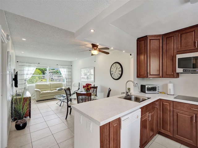 kitchen with kitchen peninsula, ceiling fan, white appliances, sink, and light tile floors