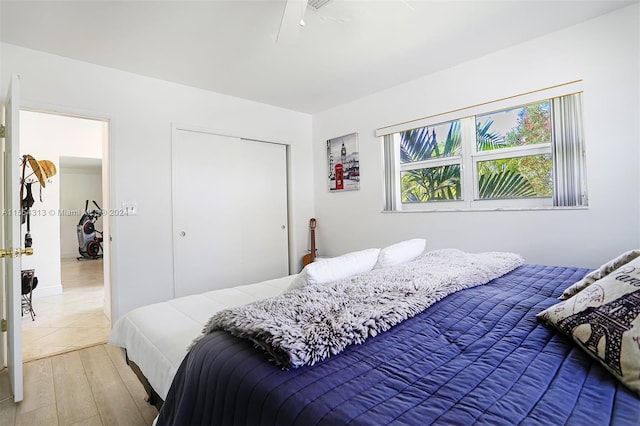 bedroom with hardwood / wood-style floors, ceiling fan, and a closet