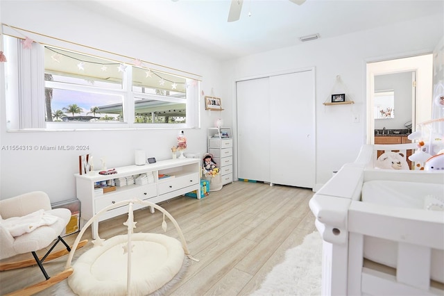 bedroom featuring light hardwood / wood-style flooring, ceiling fan, and a closet