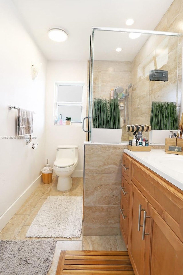 bathroom featuring toilet, vanity, tile patterned flooring, and a shower with door