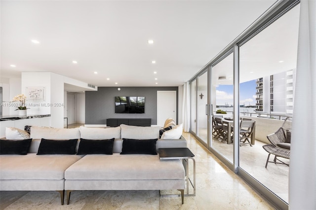 tiled living room featuring a wall of windows