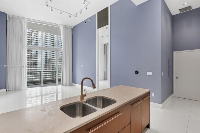 kitchen with track lighting, light tile floors, and sink