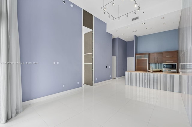 interior space featuring an inviting chandelier, black microwave, light tile floors, and wall oven