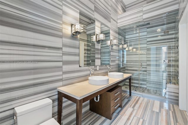 bathroom with toilet, a shower with shower door, and large vanity