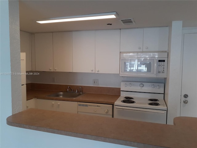 kitchen featuring white appliances, white cabinetry, and sink