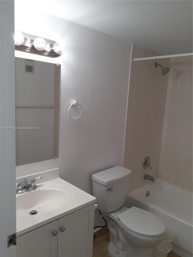 full bathroom featuring toilet, vanity with extensive cabinet space, and tiled shower / bath combo