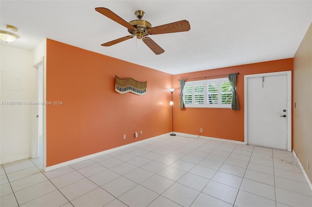 tiled spare room with ceiling fan