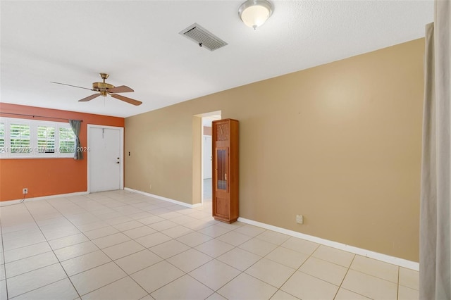 tiled spare room with ceiling fan