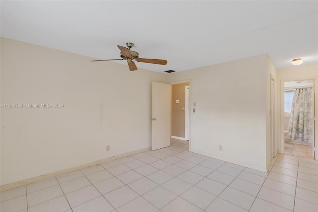 tiled spare room with ceiling fan