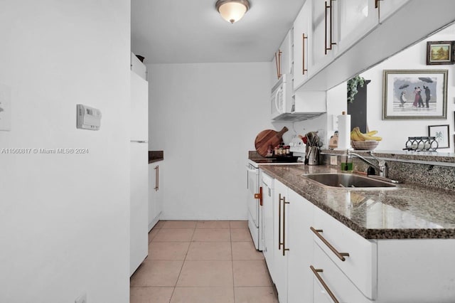 kitchen with sink, white appliances, light tile floors, and white cabinetry